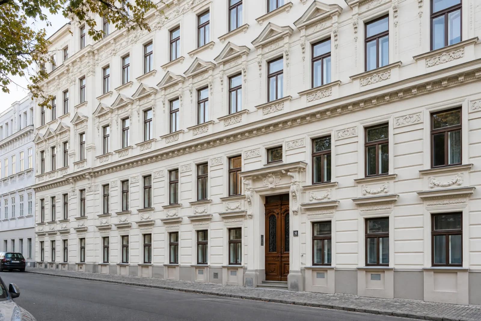 Sanierte Gründerzeitfassade mit restauriertem Stuck und neuen Holzfenstern in Wien