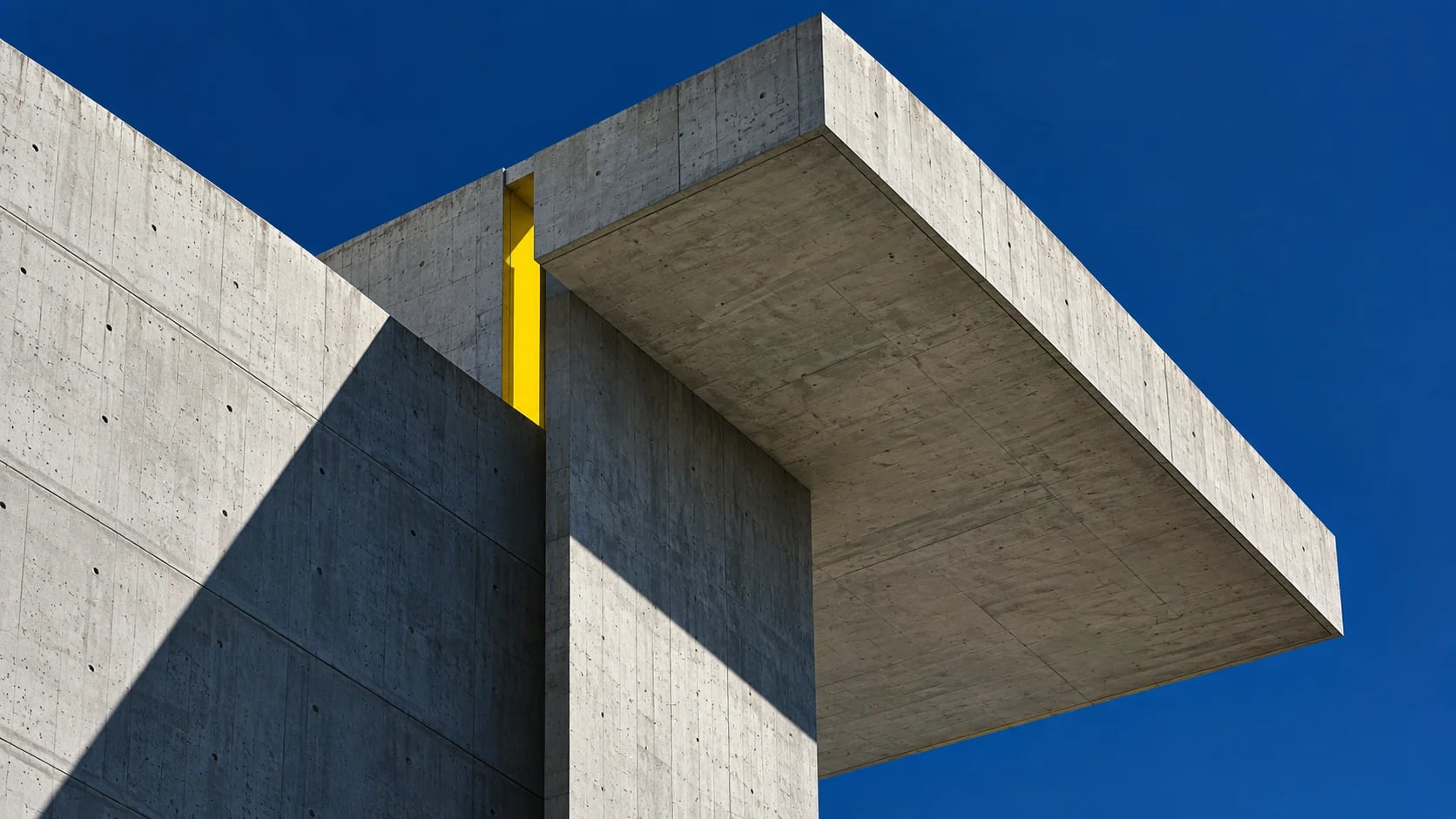 Symbolbild einer Sichtbetonarchitektur mit gelbem Fassadendetail
